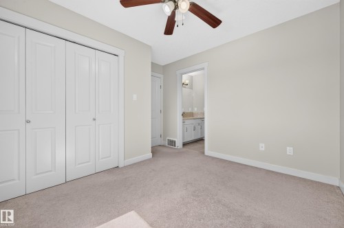 Neutral-toned carpeting throughout this room, featuring a ceiling fan with integrated lighting - 1512 Cunningham Cape, Edmonton, AB 