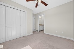 Neutral-toned carpeting throughout this room, featuring a ceiling fan with integrated lighting - 