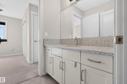 Bathroom vanity with a speckled countertop, undermount sink, and brushed nickel faucet - 