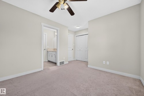 Neutral-toned wall paint with a ceiling fan, plush carpet, and white trim - 1512 Cunningham Cape, Edmonton, AB 