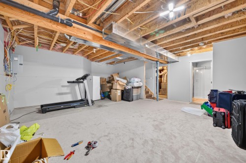 Unfinished basement with exposed ceiling joists and plumbing, offering expansive open space - 1512 Cunningham Cape, Edmonton, AB 