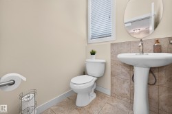 Pedestal sink with chrome faucet, complemented by a round wall mirror - 