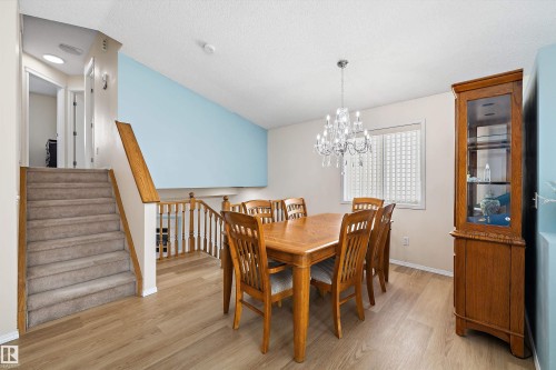 Open dining area featuring wood-finish flooring and a crystal chandelier - 15016 134 Street, Edmonton, AB 