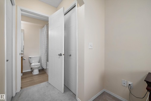Hallway featuring light-toned carpeting and neutral wall tones - 15016 134 Street, Edmonton, AB 