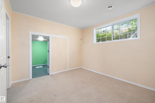 Carpeted room with a rectangular window and a flush mount ceiling light - 15016 134 Street, Edmonton, AB 
