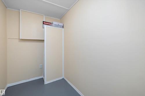 Utility space with light beige walls, white trim, a suspended ceiling, and gray flooring - 15016 134 Street, Edmonton, AB 