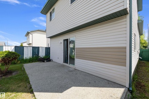 Rear exterior featuring light-colored siding with a contrasting horizontal accent band - 15016 134 Street, Edmonton, AB 