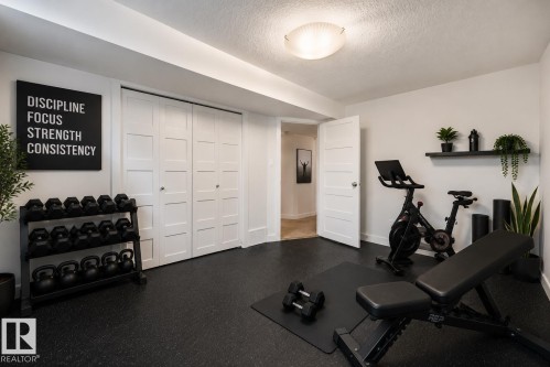 Dedicated fitness area featuring durable black rubber flooring - 8212 148 Street Nw, Edmonton, AB 