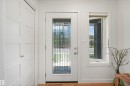 Entryway featuring a decorative glass panel door with a sidelight, white trim, and a flat-panel closet door with a chrome knob - 8212 148 Street Nw, Edmonton, AB 