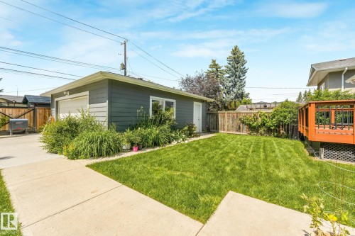 Detached garage with a single overhead door, an exterior side door, and a window - 8212 148 Street Nw, Edmonton, AB 