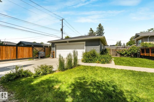 Detached garage featuring a white overhead door and gray siding - 8212 148 Street Nw, Edmonton, AB 