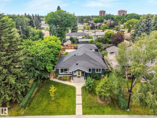 Contemporary residence with dark siding and a contrasting yellow entry door - 8212 148 Street Nw, Edmonton, AB 