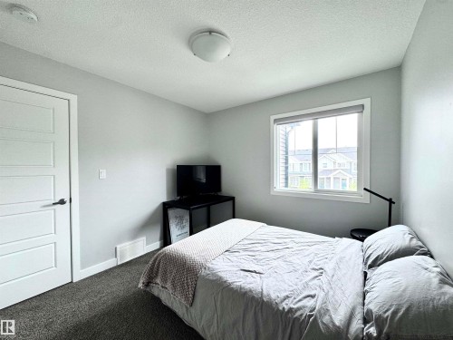 Carpeted bedroom featuring light gray walls and a single window with white trim - 7432 Elmer Road, Edmonton, AB 