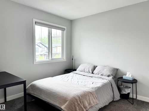 Bedroom featuring light grey walls, white trim, and dark grey carpet flooring - 7432 Elmer Road, Edmonton, AB 