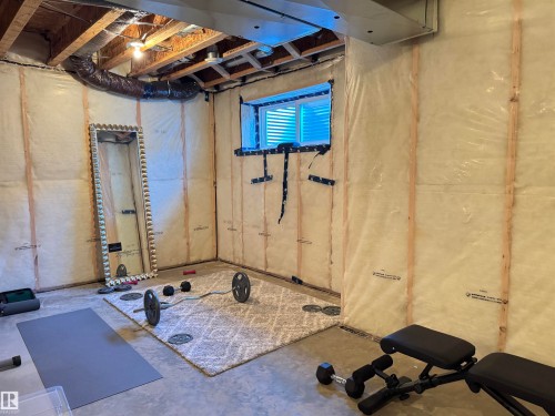 Unfinished basement space with exposed ceiling joists and visible insulation - 7432 Elmer Road, Edmonton, AB 