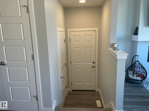 Entryway featuring wood-finish flooring, recessed lighting, and a white paneled door - 7432 Elmer Road, Edmonton, AB 