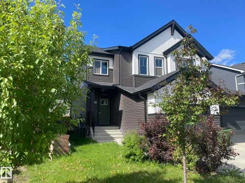 Contemporary two-story exterior featuring dark horizontal siding and vertical white accents - 7432 Elmer Road, Edmonton, AB 