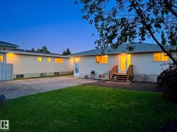 Rear exterior featuring a backyard, stucco siding, and a multi-level wood deck - 