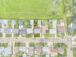 Aerial perspective showcasing a residential property with a green lawn - 