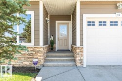 Front exterior featuring a multi-tone stone facade, composite siding, and white trim - 
