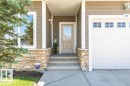 Front exterior featuring a multi-tone stone facade, composite siding, and white trim - 15 175 Mcconachie Drive, Edmonton, AB 