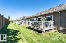 Rear exterior featuring a private deck with glass railing, durable horizontal siding, multiple windows, and a shingle roof - 