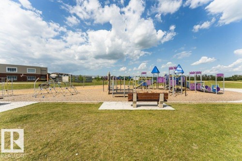 Expansive outdoor recreation area featuring a large playground with multiple structures, including slides and climbing apparatus - 15 175 Mcconachie Drive, Edmonton, AB 