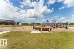 Expansive outdoor recreation area featuring a large playground with multiple structures, including slides and climbing apparatus - 