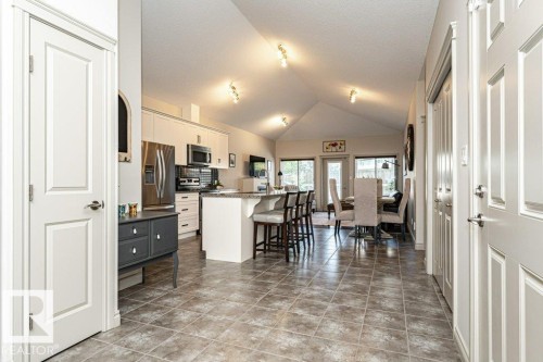 Spacious open-concept living area featuring a vaulted ceiling and recessed lighting - 15 175 Mcconachie Drive, Edmonton, AB 