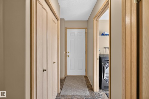 Hallway with light beige walls and wood-finish trim and doors - 13406 32A Street, Edmonton, AB 