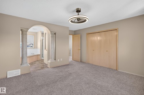 Carpeted room with a modern ceiling light fixture and neutral-toned walls - 13406 32A Street, Edmonton, AB 