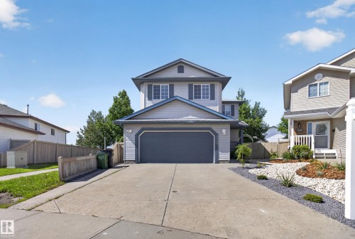 Two-story residence featuring light gray siding with dark gray window shutters and trim - 13406 32A Street, Edmonton, AB 