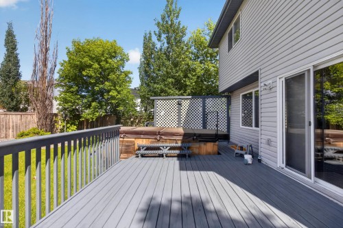 Expansive gray composite deck featuring a privacy screen and integrated spa - 13406 32A Street, Edmonton, AB 
