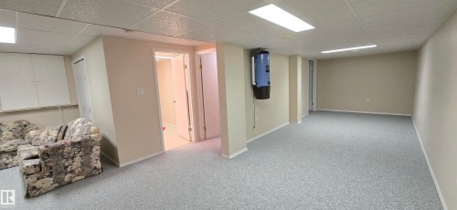 Spacious lower level featuring light gray carpeting, neutral-toned walls, and recessed lighting - 4734 54A Avenue, Vegreville, AB - Indoor Photo Showing Basement