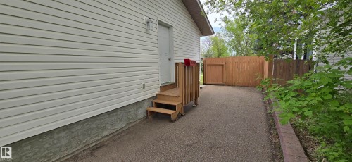 White vinyl siding exterior with a single entry door and wooden steps - 4734 54A Avenue, Vegreville, AB - Outdoor With Exterior