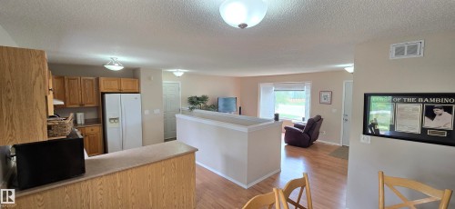 Open-concept living space featuring wood-finish flooring, recessed lighting, and a bay window - 4734 54A Avenue, Vegreville, AB - Indoor Photo Showing Kitchen