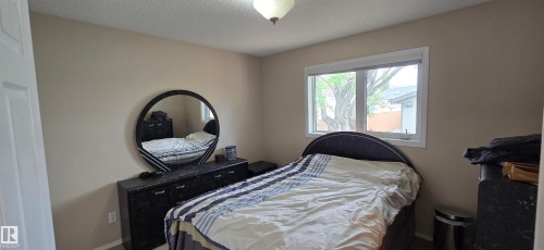 Bedroom featuring a neutral color palette, a ceiling-mounted light fixture, and a window with white trim - 4734 54A Avenue, Vegreville, AB - Indoor Photo Showing Bedroom