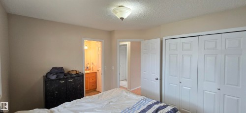 Interior room featuring neutral wall tones, textured ceiling, and a flush-mount ceiling light - 4734 54A Avenue, Vegreville, AB - Indoor Photo Showing Bedroom