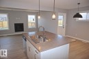 180 Radcliffe Wynd, Fort Saskatchewan, AB  - Indoor Photo Showing Kitchen With Fireplace With Double Sink 