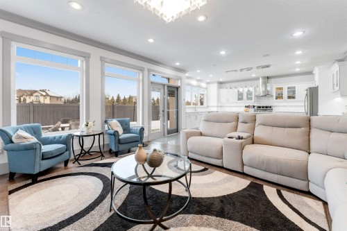 Living area featuring wood-finish flooring, recessed lighting, and large picture windows - 656 180 Street Sw, Edmonton, AB - Indoor Photo Showing Living Room