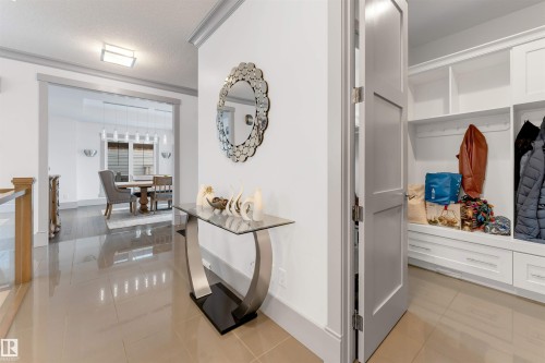 Tiled entryway with a built-in mudroom featuring custom cabinetry, shelving, and bench seating - 656 180 Street Sw, Edmonton, AB - Indoor Photo Showing Other Room