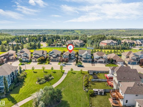 Aerial perspective showcasing a residential neighborhood with ample green spaces and distant tree lines - 656 180 Street Sw, Edmonton, AB - Outdoor With View