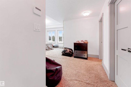 Carpeted room with white walls, a flush-mount ceiling light, and white trim - 656 180 Street Sw, Edmonton, AB - Indoor