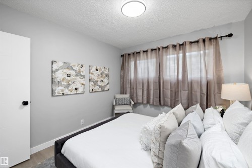 Room with light gray walls, wood-finish flooring, white baseboards, and a white door with black hardware - 12912 103 Street, Edmonton, AB 