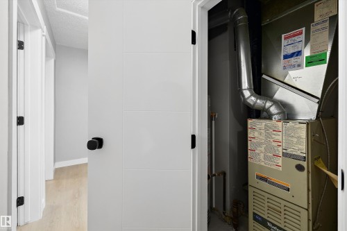 Utility closet with a central heating and air conditioning unit, featuring exposed ductwork and copper piping - 12912 103 Street, Edmonton, AB 