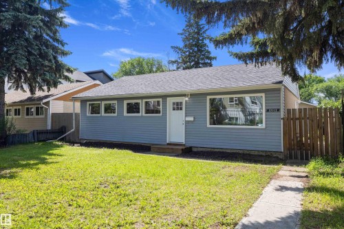 Single-story residence featuring blue horizontal siding and a gray shingle roof - 12912 103 Street, Edmonton, AB 