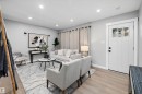 Bright living area featuring wood-finish flooring, recessed lighting, and a white paneled entry door with windowpanes - 12912 103 Street, Edmonton, AB 