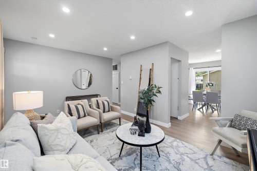 Recessed lighting illuminates this contemporary living space featuring light gray wall tones and wood-finish flooring - 12912 103 Street, Edmonton, AB 