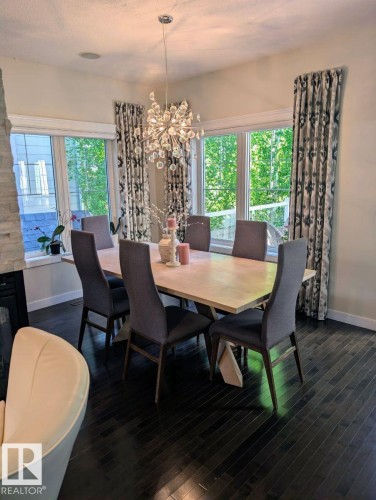 Dining area featuring dark wood-finish flooring and a contemporary chandelier - 2327 Frezenberg Avenue, Edmonton, AB 