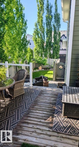 Spacious outdoor deck with a wooden surface, white railing, and direct access to a fenced yard - 2327 Frezenberg Avenue, Edmonton, AB 